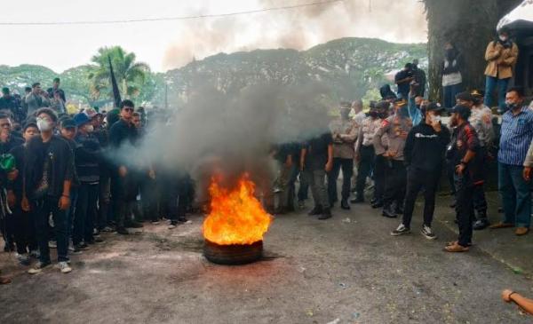 Massa HMI Malang Raya membakar ban saat aksi demonstrasi di depan Gedung DPRD Kota Malang, Selasa (22/3/2022). (Foto: MPI/Avirista Midaada)