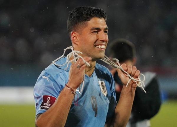 Striker Uruguay, Luis Suarez Striker Uruguay, Luis Suarez memotong jala gawang seusai timnya mengalahkan Peru dalam laga Kualifikasi Piala Dunia 2022 di Stadion Centenario, Jumat (25/3). Hasil tersebut membuat Uruguay lolos ke Piala Dunia. (Foto: REUTERS)