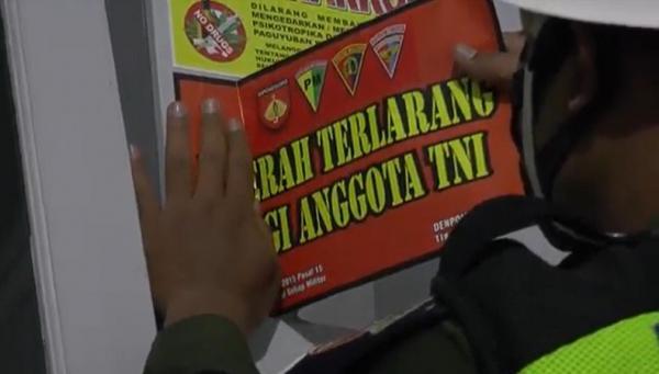 Pemasangan stiker larangan anggota TNI ke tempat hiburan malam. (Foto: iNews/Kristadi).