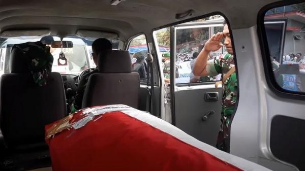 Seorang anggota memberi hormat ke peti jenazah prajurit TNI yang gugur di Yalimo saat berada dalam ambulans di halaman Kantor Airnav Sentani. (Foto: iNews/Edy Siswanto)