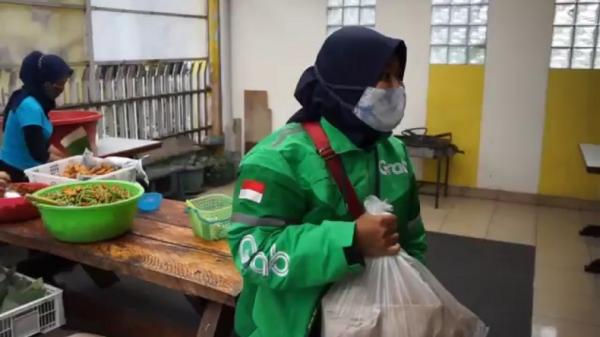 NASI BUNGKUS Pengemudi ojol membawa 15 nasi bungkus gratis untuk dibagikan kepada teman-temannya. (FOTO: iNews/ERVAN DAVID)