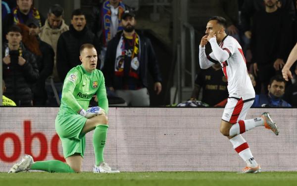 Kiper Barcelona, Marc-Andre ter Stegen terlihat lesu melihat pemain Rayo Vallecano, Alvaro Garcia merayakan gol dalam laga Liga Spanyol 2021/2022 di Stadion Camp Nou, Senin (25/4/2022). (Foto: REUTERS)
