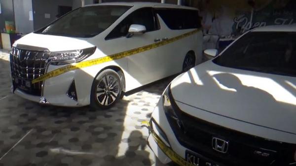 Dua mobil mewah oknum polisi berinisial Briptu HSB (baju putih) yang ditangkap kasus dugaan tambang emas ilegal di Kaltara. (Foto: iNews/Usman Coddang)