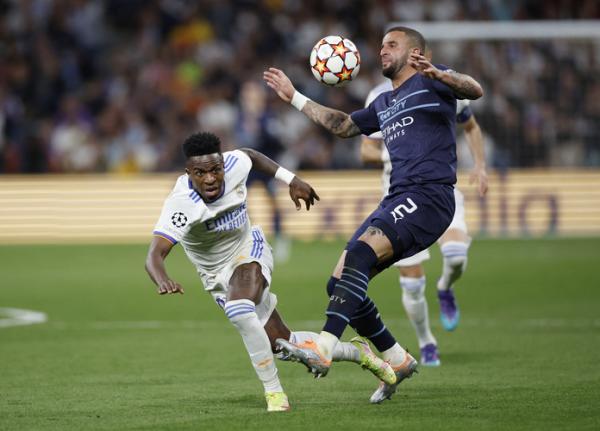 Bek kanan Manchester City, Kyle Walker Bek kanan Manchester City, Kyle Walker (kanan) merebut bola dari winger Real Madrid, Vinicius Junior dalam laga leg kedua semifinal Liga Champions 2021/2022 di Stadion Santiago Bernabeu, Kamis (5/5/2022). (Foto: REUTERS)