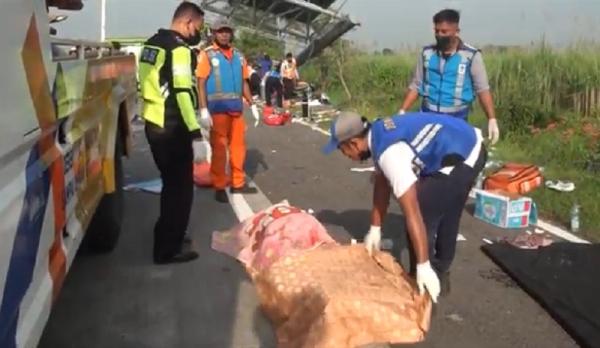 Petugas mengevakuasi korban tewas laka bur pariwisata di Tol Jombang-Surabaya, Senin (16/5/2022). (Foto: iNews.id/Sholahudin).
