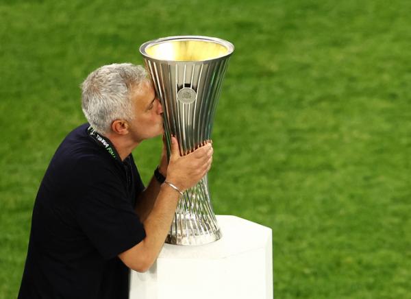 Pelatih AS Roma, Jose Mourinho mencium trofi juara Liga Koferensi Eropa 2021/2022 seusai mengalahkan Feyenoord Rotterdam di Stadion Air Albania, Tirana, Kamis (26/5). (Foto: REUTERS)