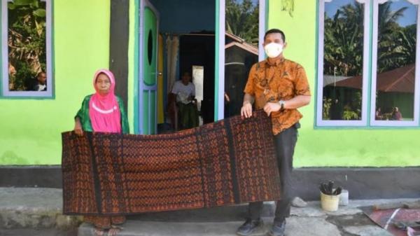 Nenek Sofia saat menujukkan kain tenun khas Ende yang dia berikan untuk Presiden Jokowi. (Foto: Ist)