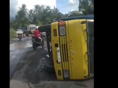 Truk bermuatan padi terguling di jalan poros Kecamatan Palas, Kabupaten Lampung Selatan akibat terperosok lubang. (Foto: iNews TV/Heri Fulistiawan)