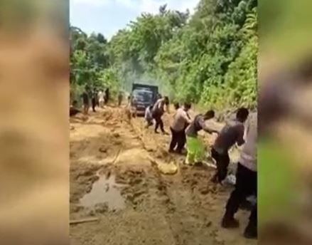 Polisi menarik truk dinas yang terjebak lumpur di Kabupaten Buton Utara. (Foto: iNews TV/Andhy Eba)
