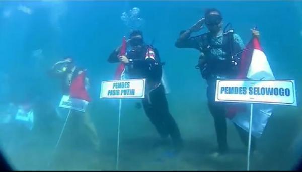 Para penyelam mengikuti upacara detik-detik proklamasi dari dasar laut, Rabu (17/8/2022). (Foto: iNews.id/Riski Amirul Ahmad).