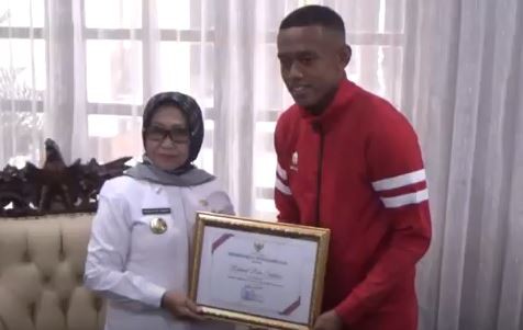 Pemain timnas Rahmat Beri Santoso menerima penghargaan dari Bupati Jombang Munjidah. (Foto: iNews/Mukhtar Bagus)