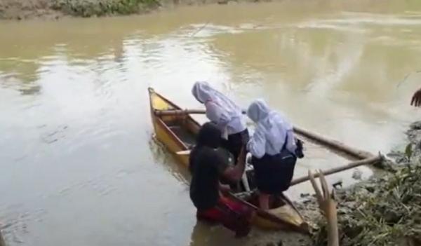 Masyarakat naik perahu akibat jembatan ambrol. (Foto: Iskandar Nasution)