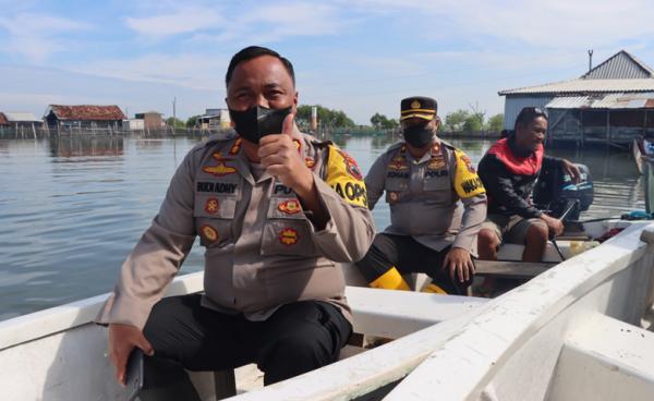 Naik Perahu, Polres Demak Salurkan Bansos kepada Warga Terdampak Abrasi dan Banjir Rob
