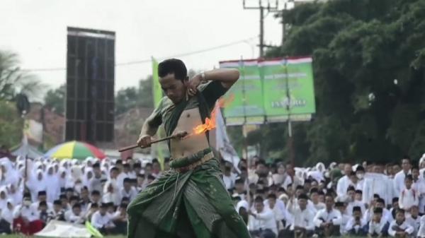 HARI SANTRI MAJALENGKA1 Seorang pria anggota Pagar Nusa melakukan atraksi kebal api untuk memeriahkan HPN 2022. (FOTO: iNews/M ZENI JOHADI)