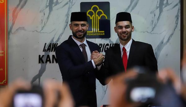 Pesepak bola Sandy Walsh mencium bendera merah putih usai melaksanakan sumpah menjadi WNI di Kanwil Kemenkumham, Jakarta, Kamis (17/11/2022). (Foto: MPI/Ilham Sigit)