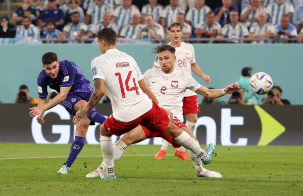 Penyerang Argentina, Julian Alvarez (kiri) melesatkan bola ke gawang Polandia pada laga terakhir Grup C Piala Dunia 2022 di Stadion  974, Doha, Kamis (1/12/2022). (Foto: REUTERS)