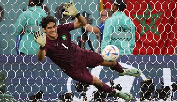 Kiper Maroko, Yassine Bounou berusaha menyelamatkan bola dari sergapan gelandang Portugal, Bruno Fernandes pada laga perempat final Piala Dunia 2022 di Stadion Al Thumama, Sabtu (10/12). (Foto: REUTERS)
