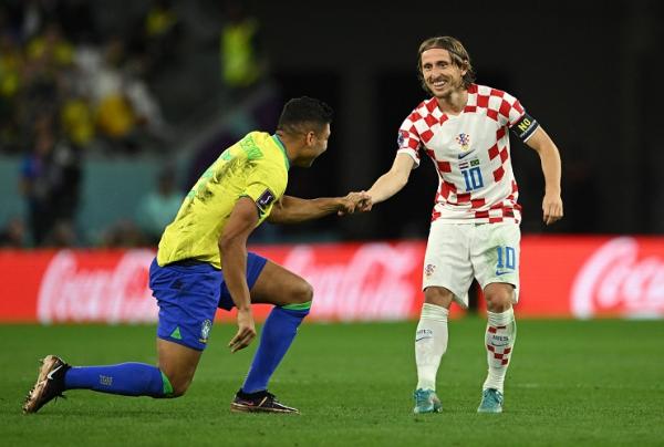 Casemiro Luka Modric Brasil Kroasia Pemain Kroasia, Luka Modric memberikan uluran tangan kepada pilar Brasil, Casemiro pada laga perempat final Piala Dunia 2022 di Stadion Education City, Jumat (9/12/2022). (Foto: REUTERS)