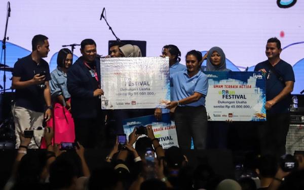 Senior Vice President Bank Mandiri Rudi As Aturridha (ketiga kiri) saat menyerahkan hadiah secara simbolik kepada mama Anna fasilitator dari rumah BUMN Kupang. (Foto: MPI/Faisal Rahman)).