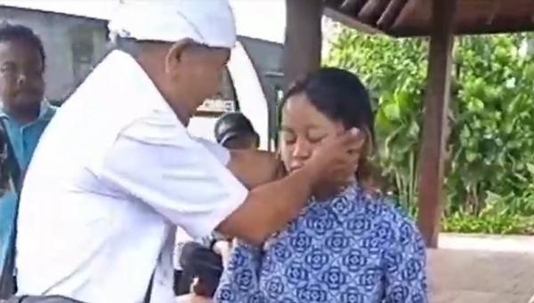 Pemangku Adat menyadarkan siswa SMP asal Sleman yang kesurupan. (Foto: Ketut Catur Kusumaningrat)