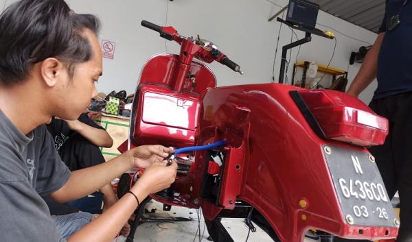 Salah satu mahasiswa magang tengah mengerjakan motor konversi BBM ke listrik. (Foto: iNews.id/ihya` ulumuddin).