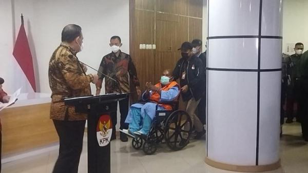 Gubernur Papua Lukas Enembe duduk di kursi roda dengan memakai rompi oranye dan tangan diborgol saat ekspose KPK. (Foto :iNews/Arie DS)