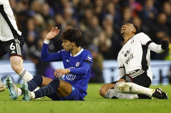 Striker baru Chelsea, Joao Felix menjegal bek Fulham, Kenny Tete pada laga Liga Inggris 2022/2023 di Stadion Craven Cottage, London, Jumat (13/1/2023). (Foto: REUTERS)