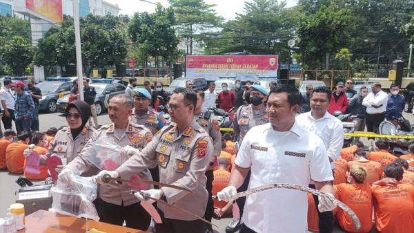 Kapolrestabes Bandung Kombes Pol Aswin Sipayung didampingi Kasatreskrim AKBP Arief Prasetya menunjukkan senjata tajam yang digunakan para pelaku kejahatan jalanan. (FOTO: iNews.id/AGUS WARSUDI)
