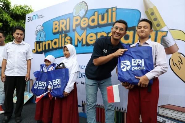 Senior Manager CSR BRI, M Ganjar Nugraha, menyerahkan bantuan peralatan sekolah kepada salah satu murid MI al-Badriyah Gunung Geulis, Bogor, Sabtu (28/1/2023). (Foto: Dok. BRI)