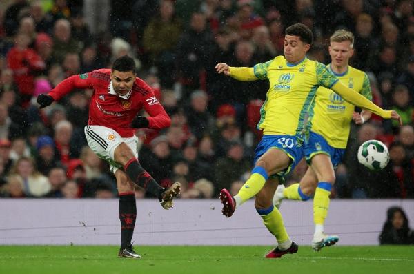 Gelandang Manchester United, Casemiro menendang bola dan berusaha dihalau pemain Nottingham Forest Brennan Johnson dalam laga Piala Liga Inggris 2022/2023 di Stadion Old Trafford, Kamis (2/2/2023). (Foto: REUTERS)