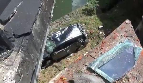 Mobil yang jatuh ke kolong jembatan usai diseruduk truk. (Foto: Ketut Catur)