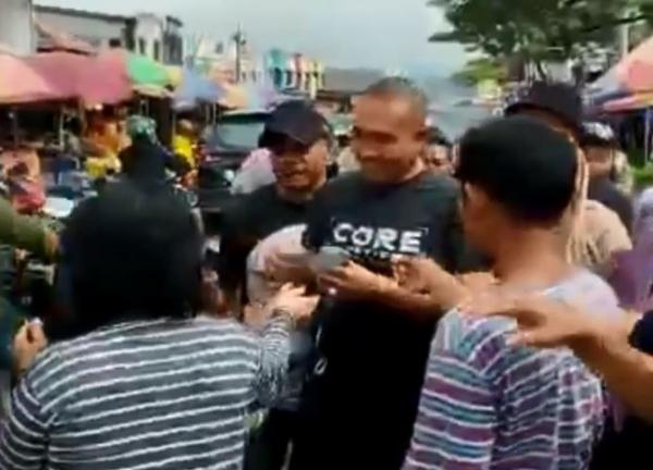 Seorang politisi membagikan uang ke warga di komplek Pasar Andonohu, Kota Kendari, Kamis (9/3/2023). (Foto: iNews/Febriyono Tamenk)
