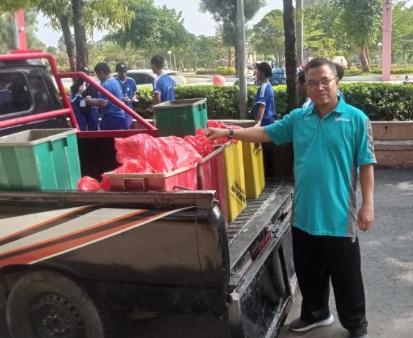Kepala SMKN 2 Purwodadi Partono memilah sampah untuk didaur ulang. (Foto: ist)