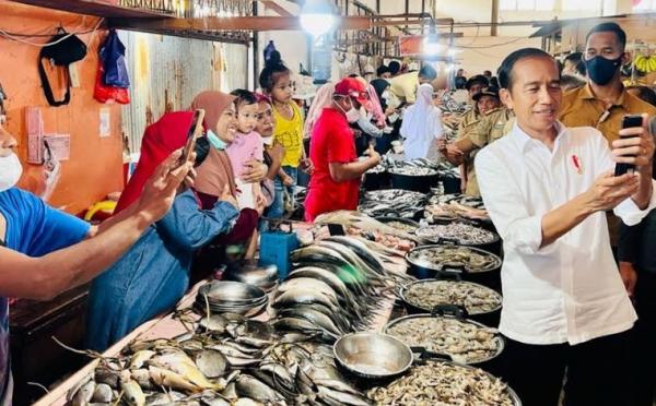 Presiden Jokowi melayani warga yang minta foto langsung saat mengunjungi Pasar Malindungi, Kabupaten Luwu Timur, Kamis (30/3/2023). (Foto: MPI)