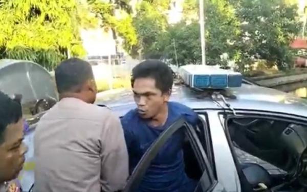 Polisi membawa paksa AHT usai menganiaya dan menikam sekuriti karaoke inisial R, Sabtu (6/5/2023). (Foto: Muhammad Nur Bone)