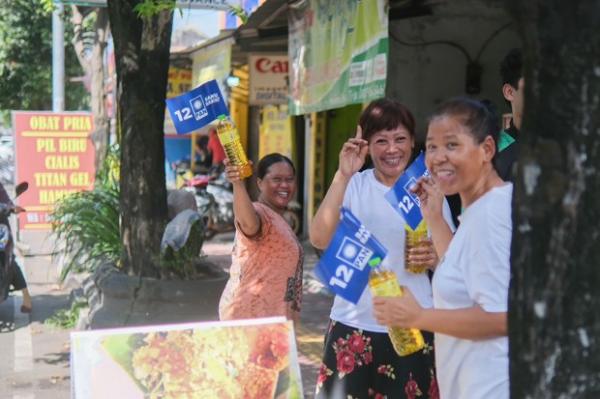 Kader PAN membagikan minyak goreng ke masyarakat, saat perjalanan menuju kantor KPU. (Foto : Ist) 