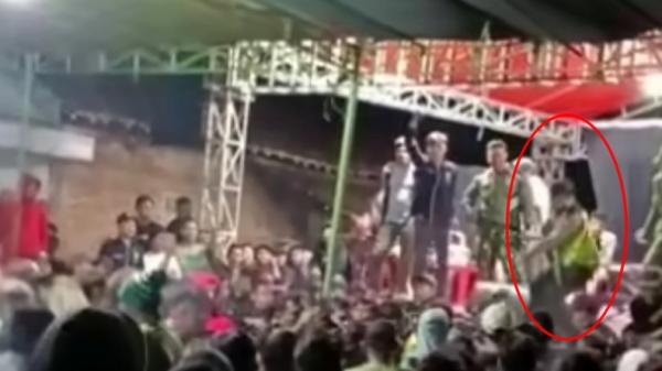 Polisi dengan mengenakan seragam yang menenteng senjata laras panjang terlihat naik ke panggung hiburan saat ada kericuhan di acara hiburan wilayah Gunungkidul, Yogyakarta (Instagram/Gunungkidulupdate)