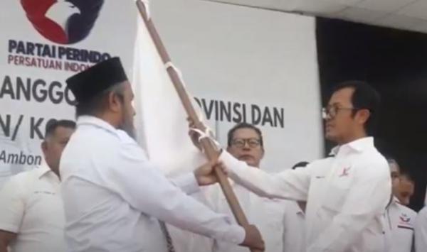 Sekjen DPP Partai Perindo Ahmad Rofiq menyerahkan bendera kebesaran Partai Perindo ke pengurus DPW Partai Perindo yang baru dilantik, Rabu (21/6/2023). (Foto: iNews/Nurdin Abdullah)