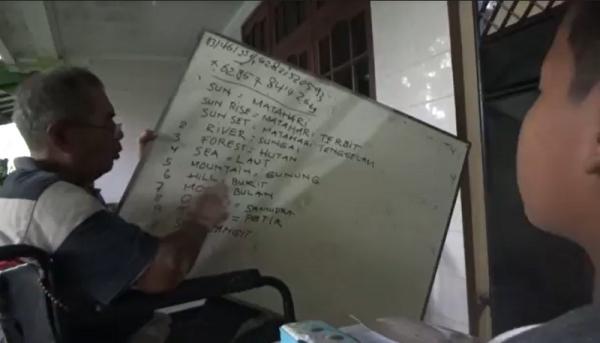 Kakek Sutanto saat mengajar bahasa Inggris kepada anak-anak di Jombang. (Mukhtar Bagus).