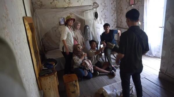 Pengunjung berfoto dengan cosplay hantu ibu dan pocong di rumah Pengabdi Setan. (FOTO: iNews/ERICK FAHRIZAL)