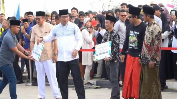 Gubernur Jabar Ridwan Kamil menyerahkan bantuan modal kepada santri yang berhasil mengembangkan produk. (FOTO: iNews/ERVAN DAVID)