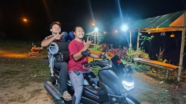 Khilmi Sabihisma membawa perlengkapan tenda ke bumper Lembah Baung, Pacet.