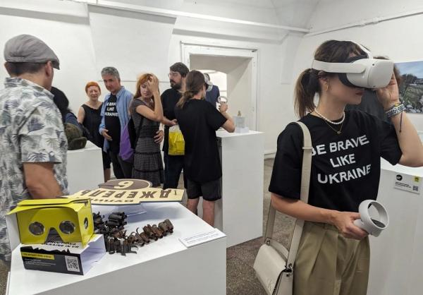 Pengunjung pameran War up Close di Berlin, Jerman, menggunakan kacamata VR untuk menyaksikan kehancuran yang ditimbulkan oleh agresi militer Rusia di kota-kota Ukraina secara virtual, 20 Juni 2023. (Foto:  war.city)
