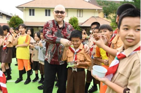 Koordinator Alumni SMA Amkur Angkatan 1997, Harryanto Aryodiguno menyalami siswa SD Amkur Pemangkat. (Foto: ist)