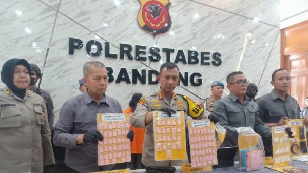 Kapolrestabes Bandung Kombes Pol Budi Sartono didampingi Kasatresnarkoba AKBP Fauzan Syahrir (dua dari kanan) menunjukkan barang bukti ekstasi, sabu, dan alat reproduksi. (FOTO: iNews.id/AGUS WARSUDI)