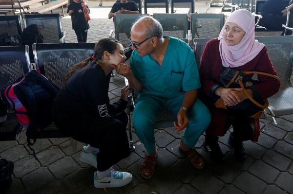 Dokter Palestina, Mohammad Abu Namoos (tengah), mengucapkan selamat tinggal kepada keluarganya sebelum mereka meninggalkan Jalur Gaza melalui perbatasan Rafah, 7 November. 2023.  Namoos memilih tetap tinggal di Gaza untuk merawat pasien di wilayah itu. (Foto: Reuters)
