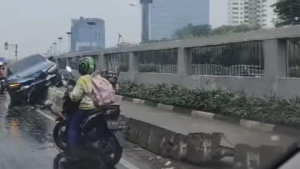 sedan_bmw_tersangkut_di_separator_busway