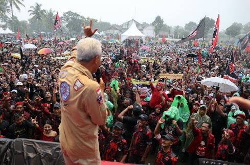 Capres nomor urut 3 Ganjar Pranowo menyapa ribuan pendukungnya yang rela hujan-hujanan saat hajatan rakyat di Magelang, rabu (7/2/2024). (foto: ist)