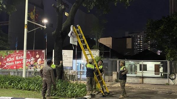 Petugas gabungan yang terdiri dari TNI-Polri, Satpol PP, Sudishub, dan lainnya, membersihkan alat peraga kampanye di Jakarta. (Foto: Fadli)