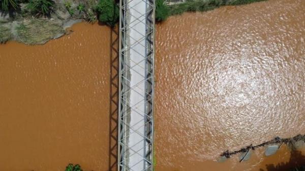 Kondisi perairan berwarna merah kecoklatan dari jembatan penghubung Desa Patowonua-Pitulua, Kolaka Utara. (Foto: iNews/Muh Rusli)